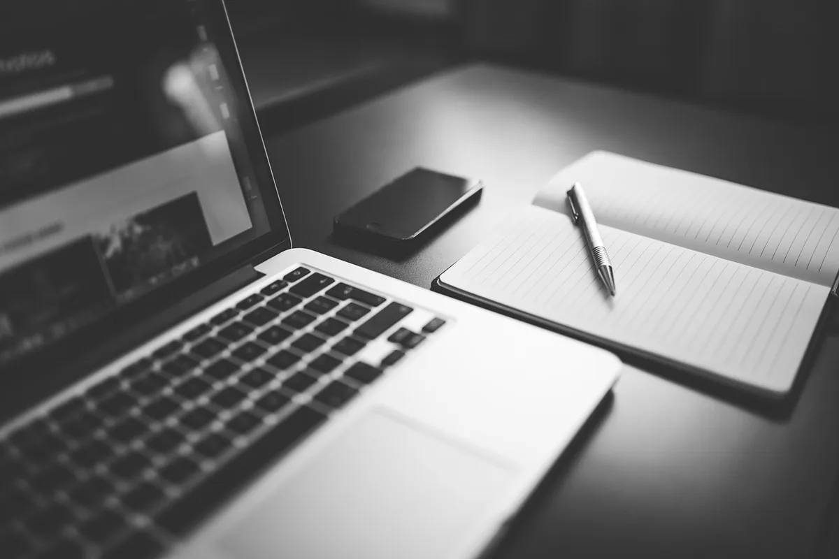Main écrivant des repères pour l'oralité dans un carnet près d'un micro