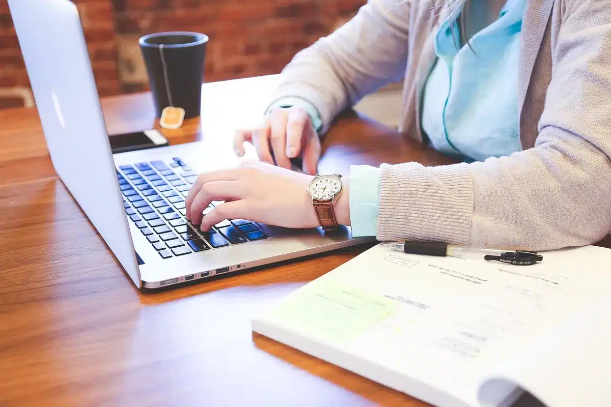 Table de travail avec écran affichant un agrégateur RSS et une tasse de café