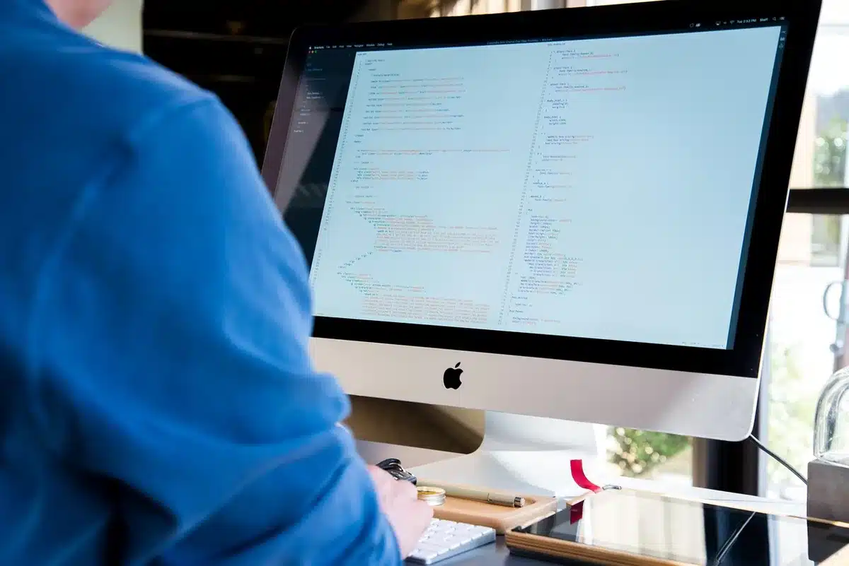 Ordinateur portable sur un bureau avec serveur en arrière-plan, évoquant auto-hébergement