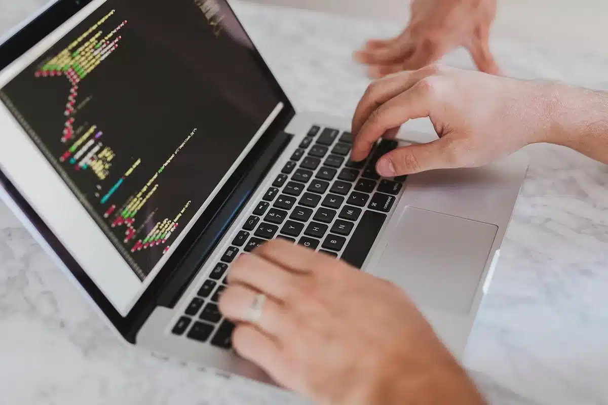 Ordinateur portable affichant du code, posé sur un bureau lumineux